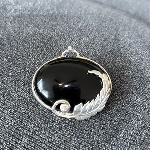 vintage Mexican sterling silver brooch featuring a black onyx and a leaf design